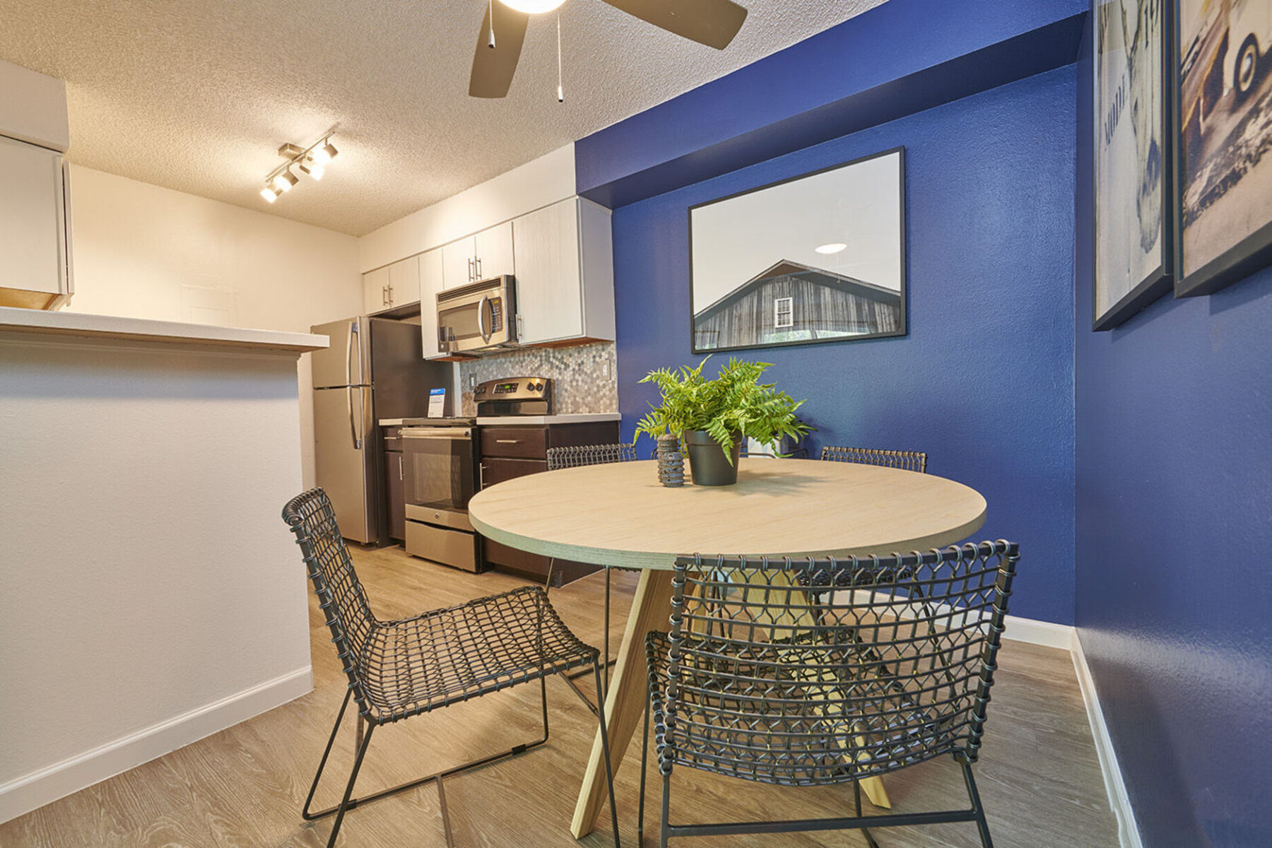 Dining area next to kitchen with a blue accent wall