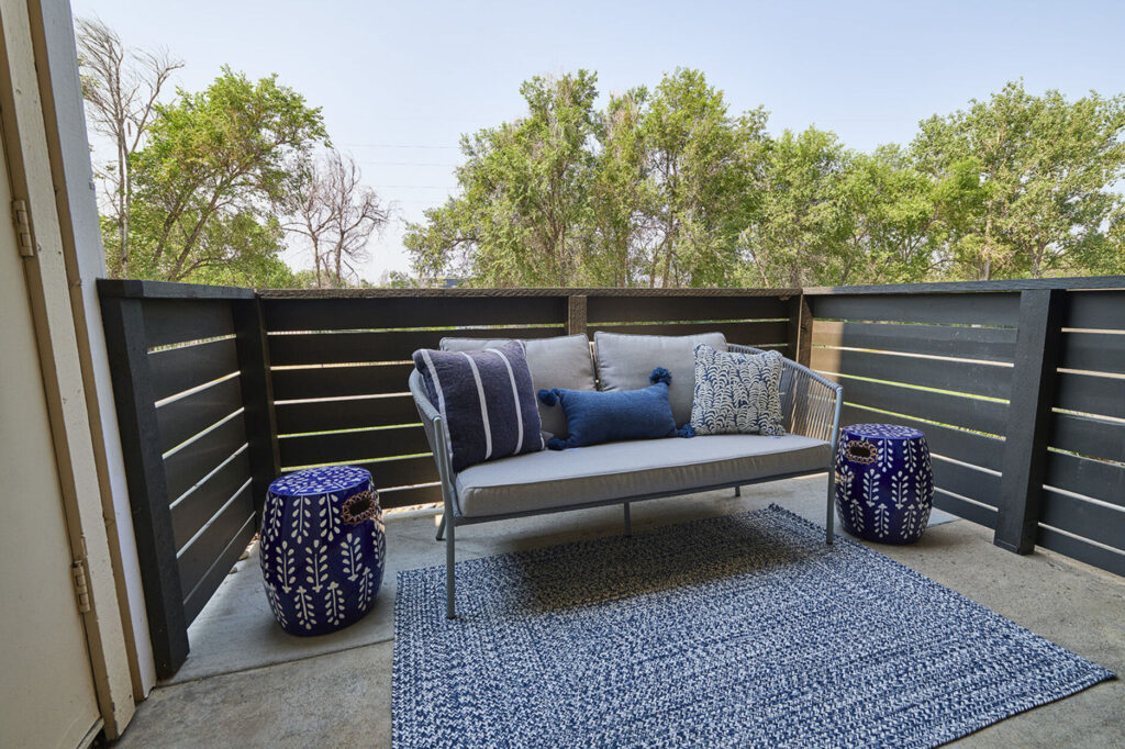 Balcony staged with a small couch and side tables